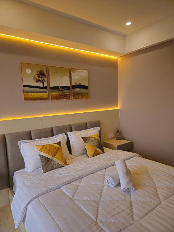雅加达Studio Apartment at Gold Coast PIK的卧室配有带枕头的大型白色床