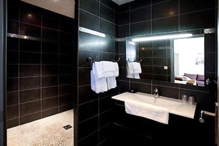 Rogliano尤桑塔涅鲁酒店的浴室配有盥洗盆、镜子和毛巾