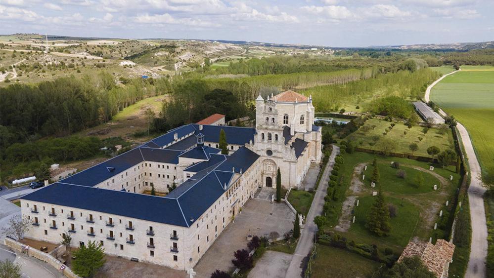 La Vid y BarriosHospedería Monasterio de La Vid的享有蓝色屋顶的大型建筑的空中景致