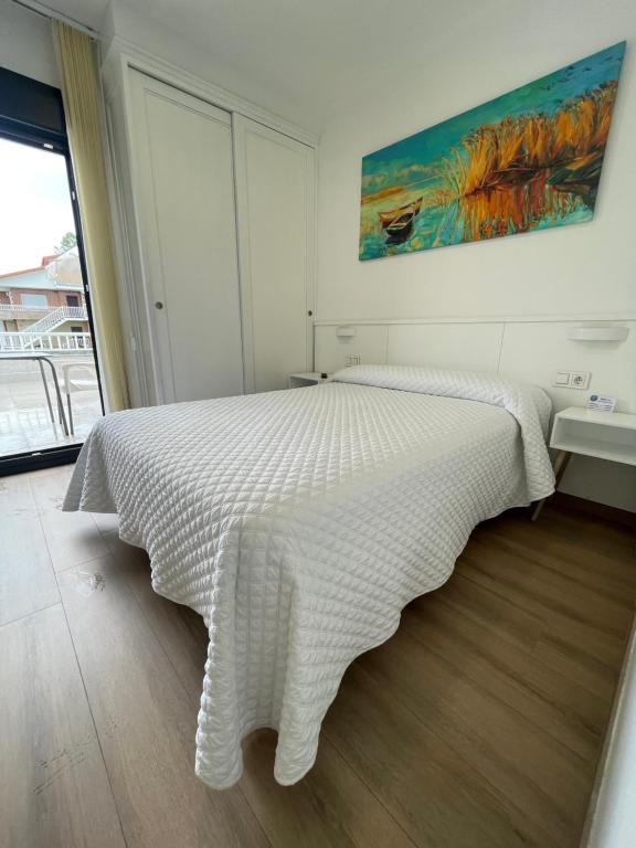 尼格兰Hostal montevideo的卧室配有白色的床铺和白色的毯子