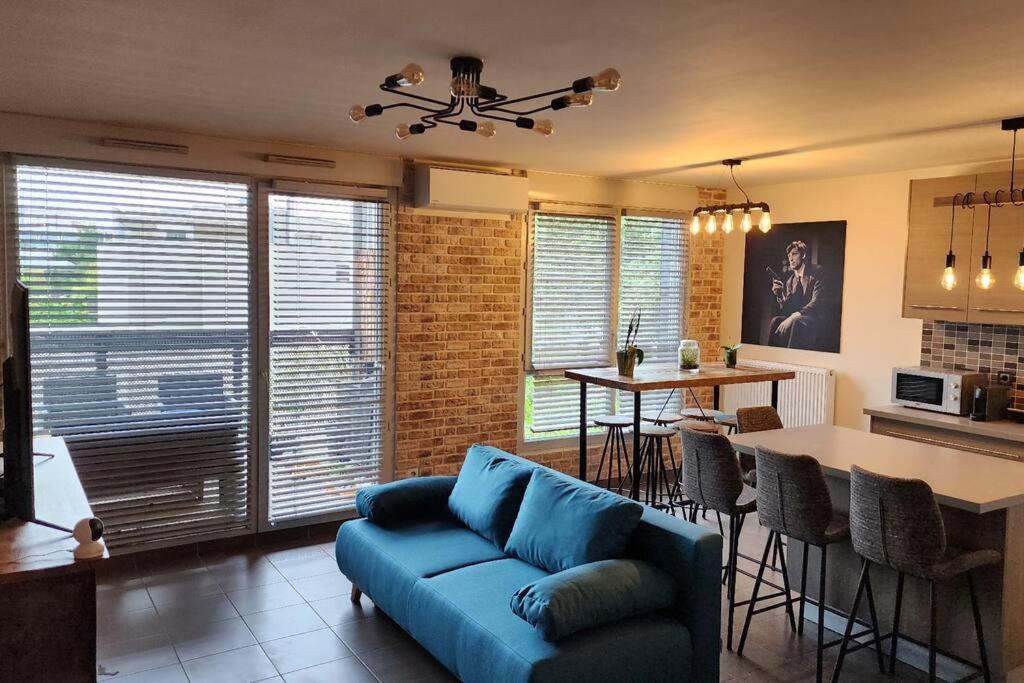 里昂Appartement Voie Lactée Lyon的一间带蓝色沙发的客厅和一间厨房