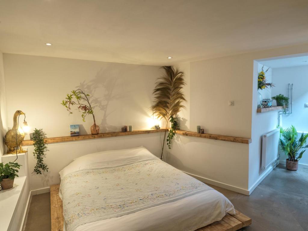 斯海弗宁恩Tiny Beachhouse的卧室配有一张挂在墙上的植物床