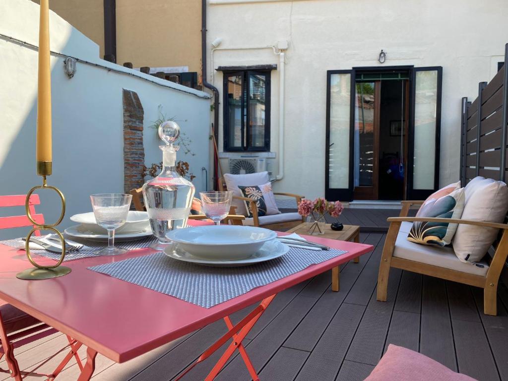 穆拉诺Central Apartment Ca' dei Ferro - MURANO Venice的天井上一张红色桌子,上面有盘子
