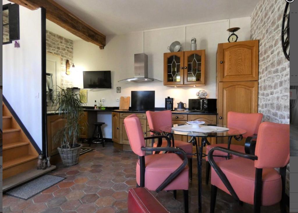 JouyLa Meunière的厨房配有桌子和一些粉红色的椅子