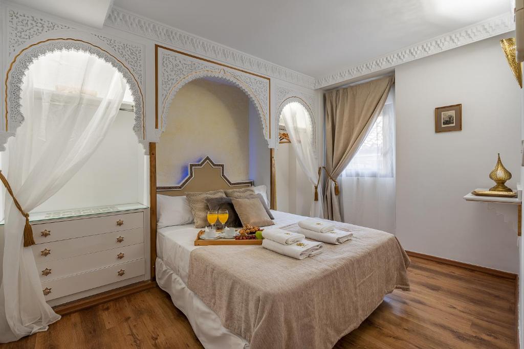 格拉纳达ADANAR-Apartamentos Muralla Zirí的一间卧室配有一张床,上面有两条毛巾