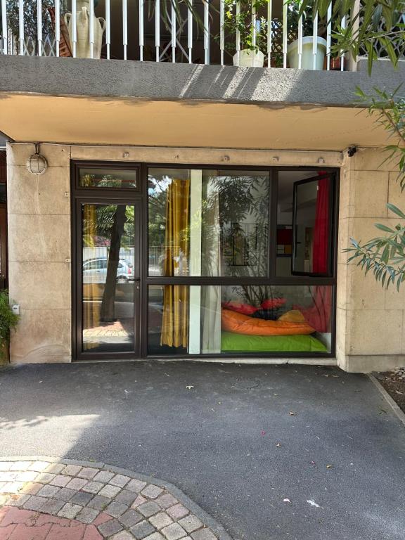 阿维尼翁POP appART Appartement Artiste 200 m du centre ville Parking privé gratuit的商店前方设有窗户,里面装有色彩缤纷的窗帘