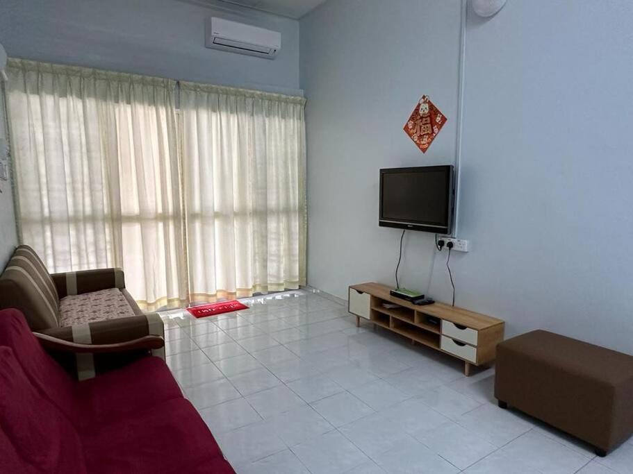大港Guan Homestay Sungai Besar 大港民宿的带沙发和平面电视的客厅