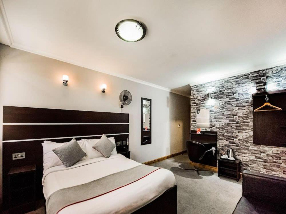伦敦Epsilon Hotel的酒店客房设有一张大床和一张书桌。