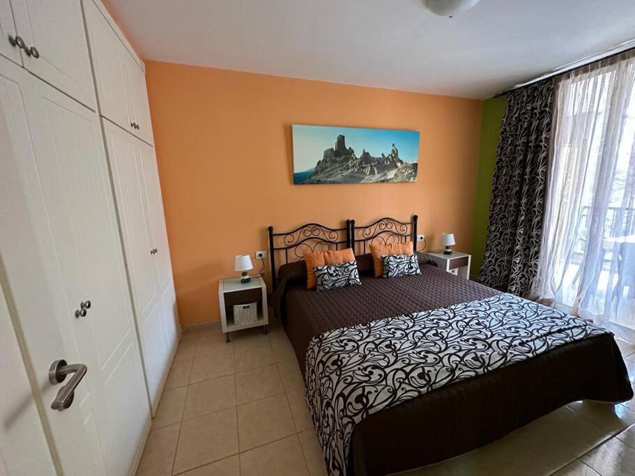 圣地亚哥港Govimar Tenerife的一间设有床铺的卧室,位于一个拥有橙色墙壁的房间