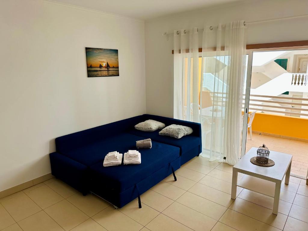 ConceiçãoApartamento Conceição de Tavira的客厅配有一张蓝色的沙发,配有一张桌子
