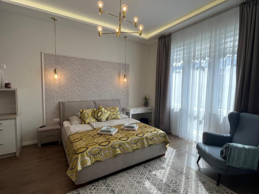 德布勒森Visit Debrecen Apartman的一间卧室配有一张床、一张沙发和一把椅子