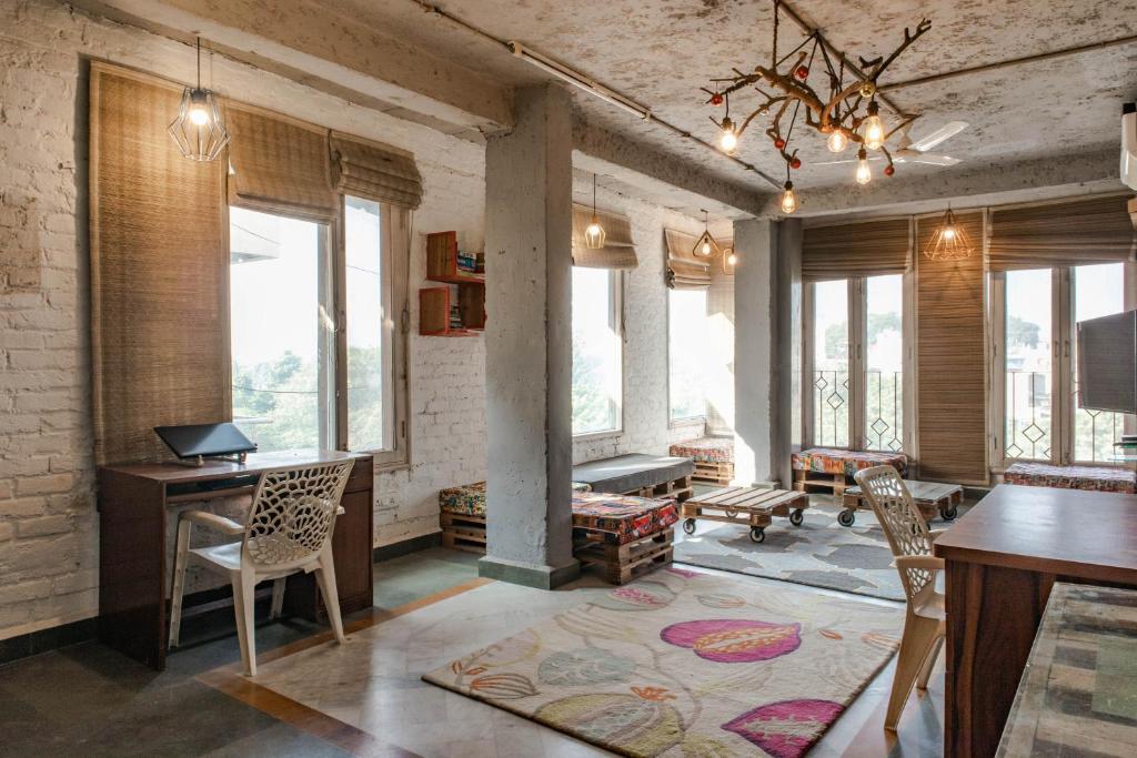 新德里JHouse near Bhikaji的客厅配有桌椅和窗户。