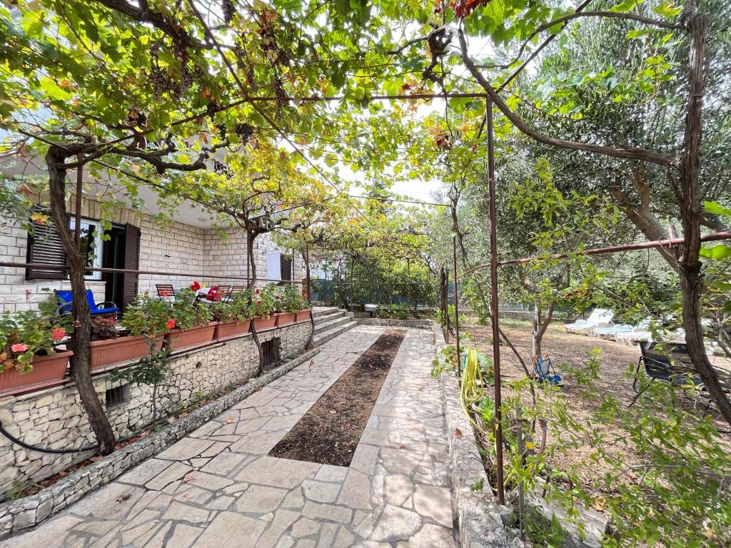 奥库格哥恩基Apartman Mišo的一座种植了植物和树木的花园,一座建筑