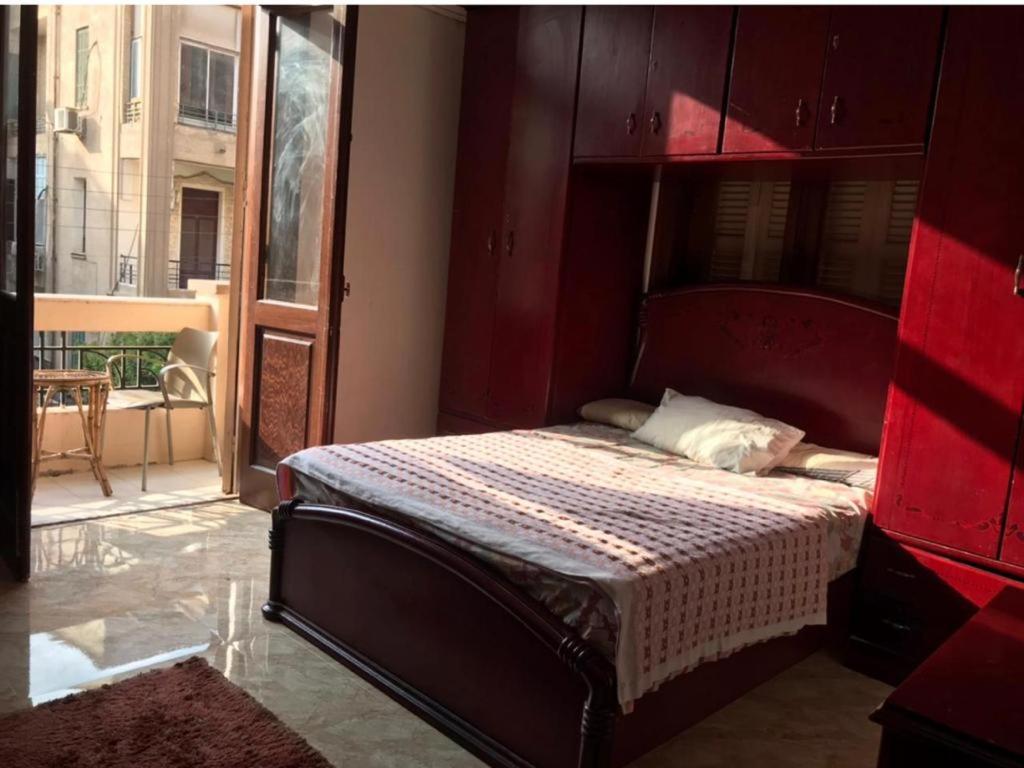 开罗مصر الجديدة - ميدان اسماعيلية - comfortable private room with balcony - Masr el gedida的一间卧室配有一张红色床头板的床