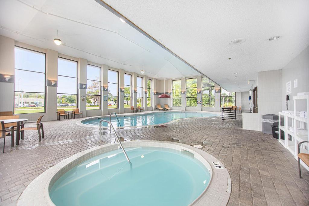 格兰德港Baymont by Wyndham Grand Haven的大楼内带热水浴池的大型游泳池