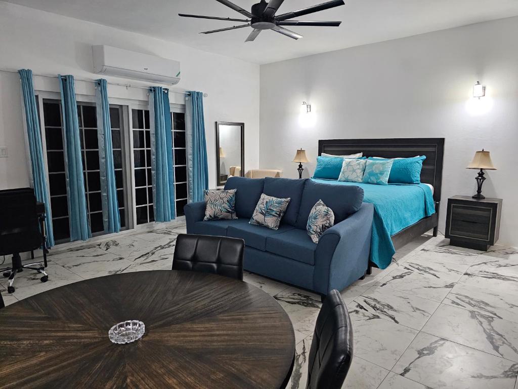 尼格瑞尔Roots Cafe Rooms的客厅配有蓝色的沙发和床。