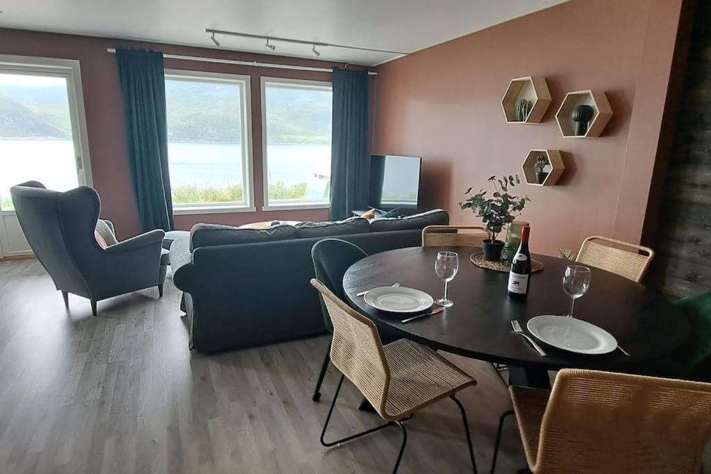 ToftaSenja, Husøy i Senja. Leilighet med utsikt over fjord og fjell的客厅配有桌子和沙发
