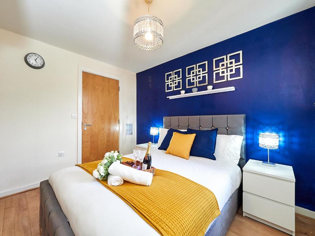 考文垂Beauchamp Suite in Coventry City Centre for Contractors Professionals Tourists Relocators Students and Family的一间卧室设有一张蓝色墙壁的大床