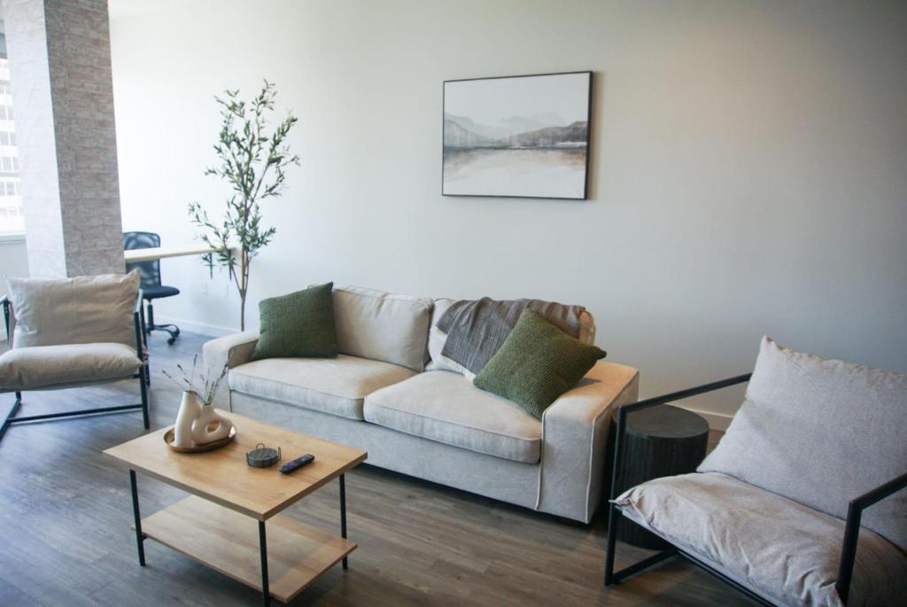 巴吞鲁日Entire High-Rise Apartment - 2BD的客厅配有沙发、两把椅子和一张桌子