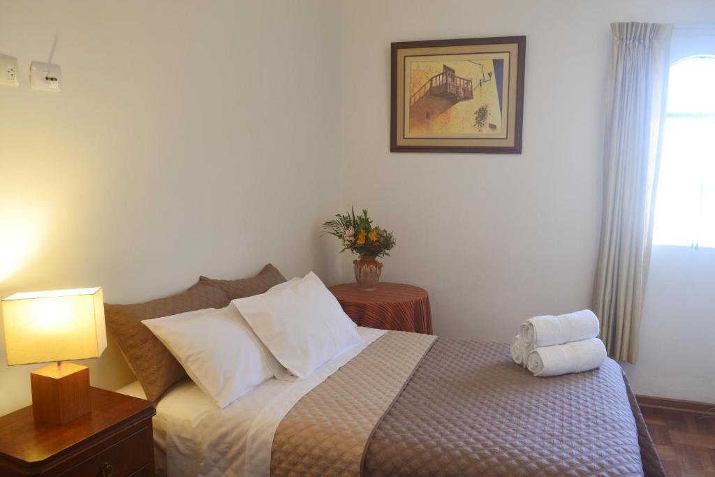 利马Casa Rodas的一间卧室配有床、灯和窗户