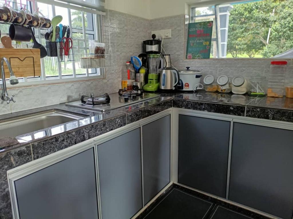 宋溪Adiniz@HotSpring Sg Klah的厨房配有不锈钢橱柜和水槽