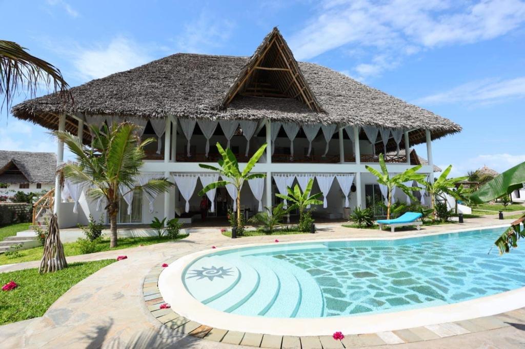 瓦塔穆Cacuki Boutique House的一座带游泳池和大楼的度假村