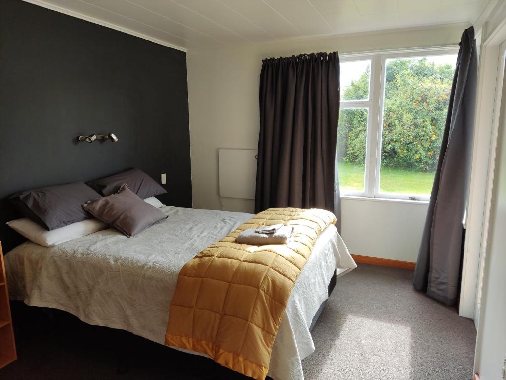 WairoaThe Frasertown Tavern的一间卧室设有一张大床和一个窗户。