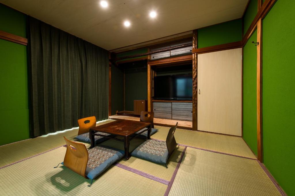 Mitsuhama三津ミーツ的客厅设有绿色的墙壁和桌椅