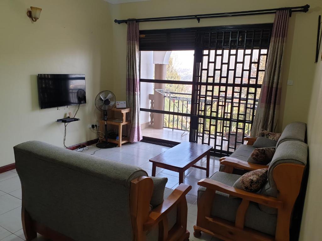 姆巴拉拉3-Bedroom Mbarara Apartment with Optional Farm Tour的客厅配有两张沙发、一张桌子和一台电视机