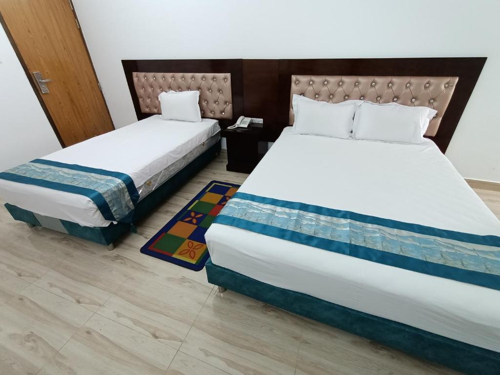 达卡Hotel D-Palace的两张睡床彼此相邻,位于一个房间里