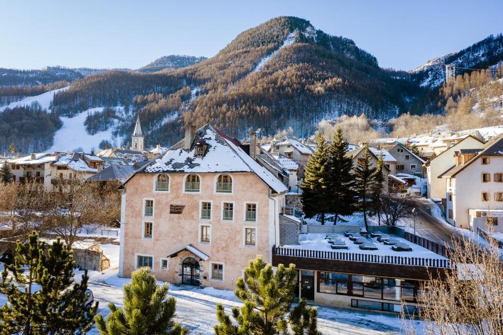 拉萨尔莱阿尔佩Auberge de Jeunesse HI Serre-Chevalier的山中的一个小镇,地面上积雪