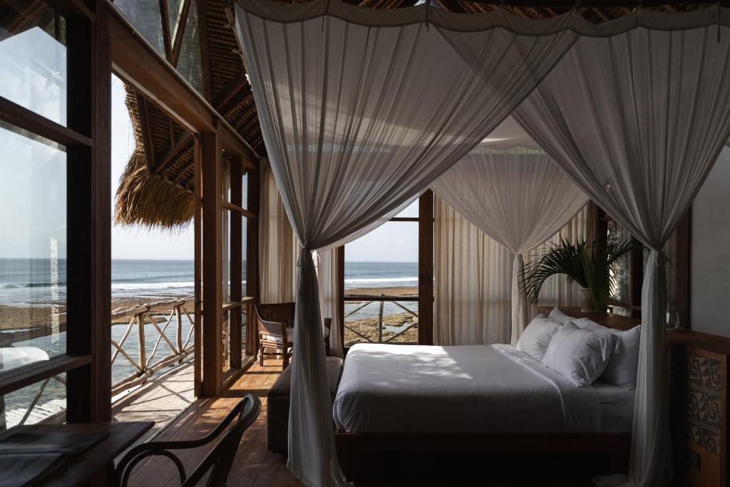 乌鲁瓦图Uluwatu Surf Shack的一间卧室设有一张床,享有海景