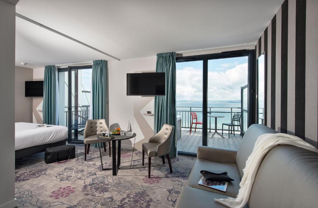 杜瓦讷内Hôtel Valdys Thalasso & Spa - la Baie的酒店客房设有一张特大号床和一个阳台。