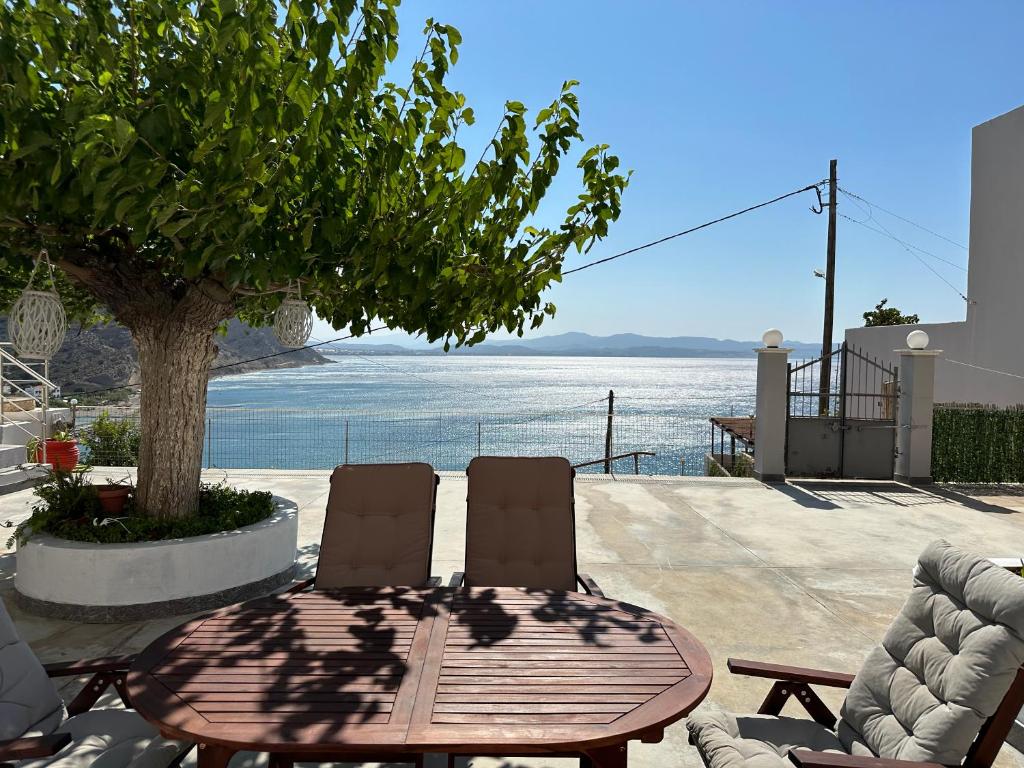 圣加利尼Irini Panorama的一张木桌和椅子,享有水景