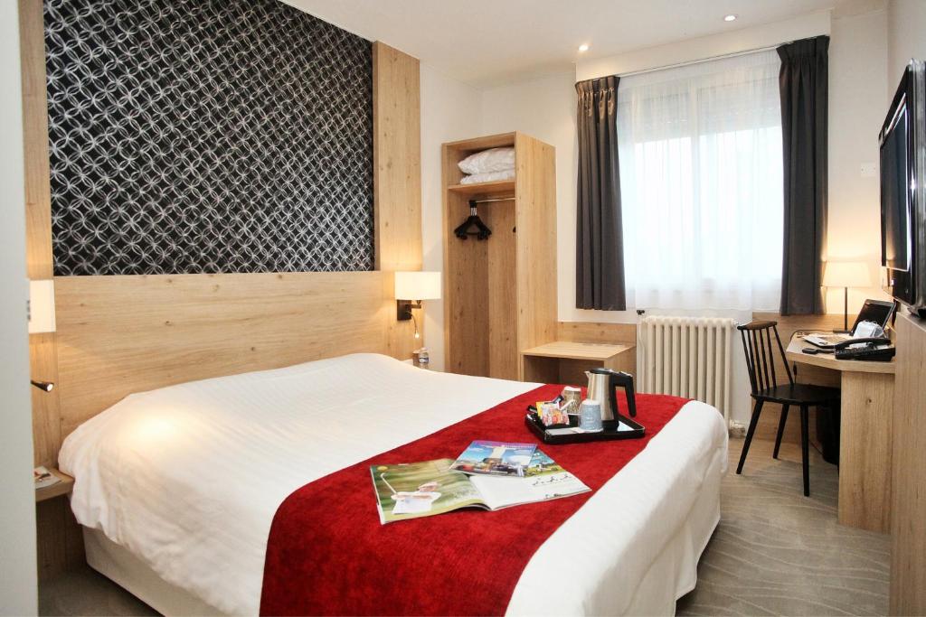 瓦讷瓦纳中心基里雅德酒店的配有一张床和一张书桌的酒店客房