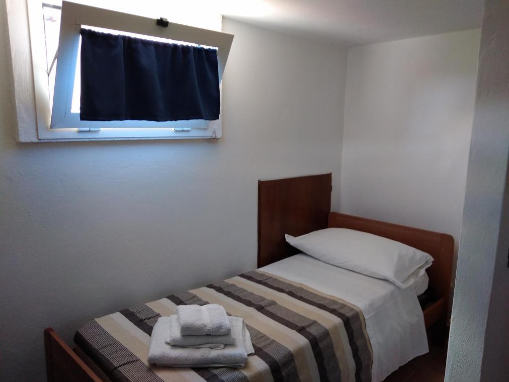 Albareto卡斯塔纳玛塔旅馆的一间卧室配有床和带毛巾的窗户。