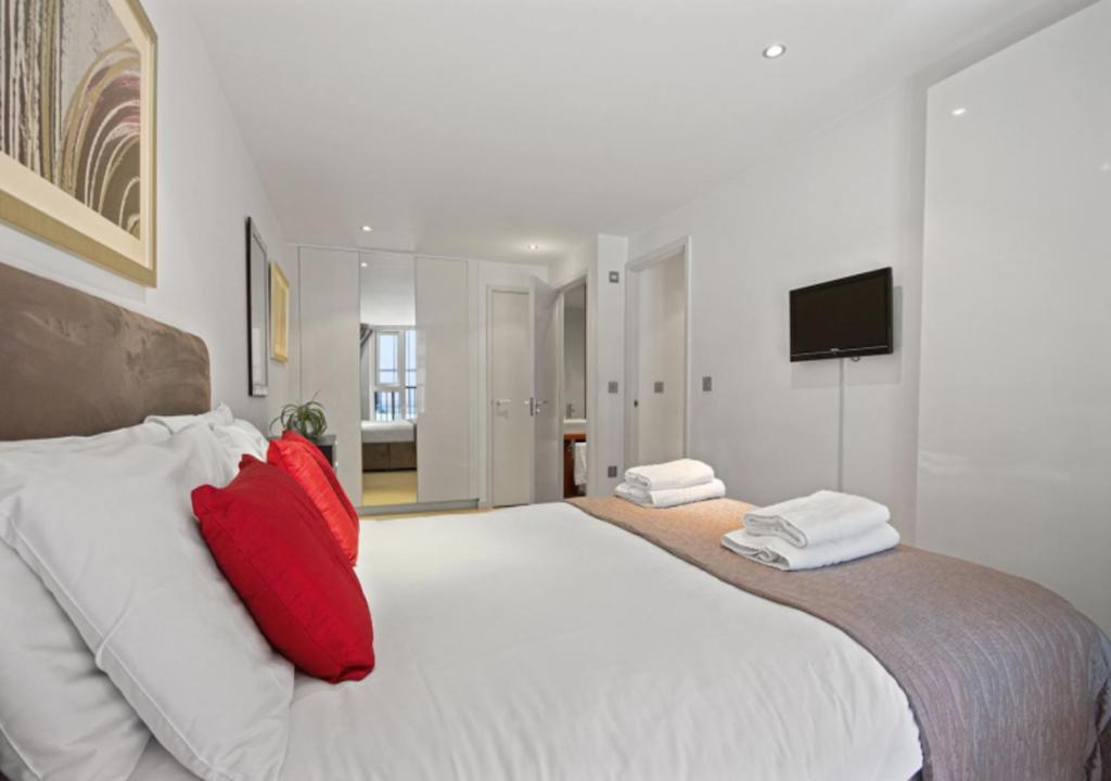 伦敦Cubo Farringdon的卧室配有带红色枕头的大型白色床