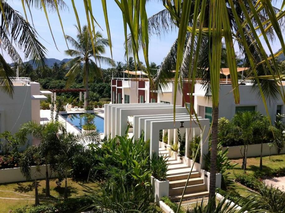 三百岭@beach village的白色的房子,设有游泳池和棕榈树