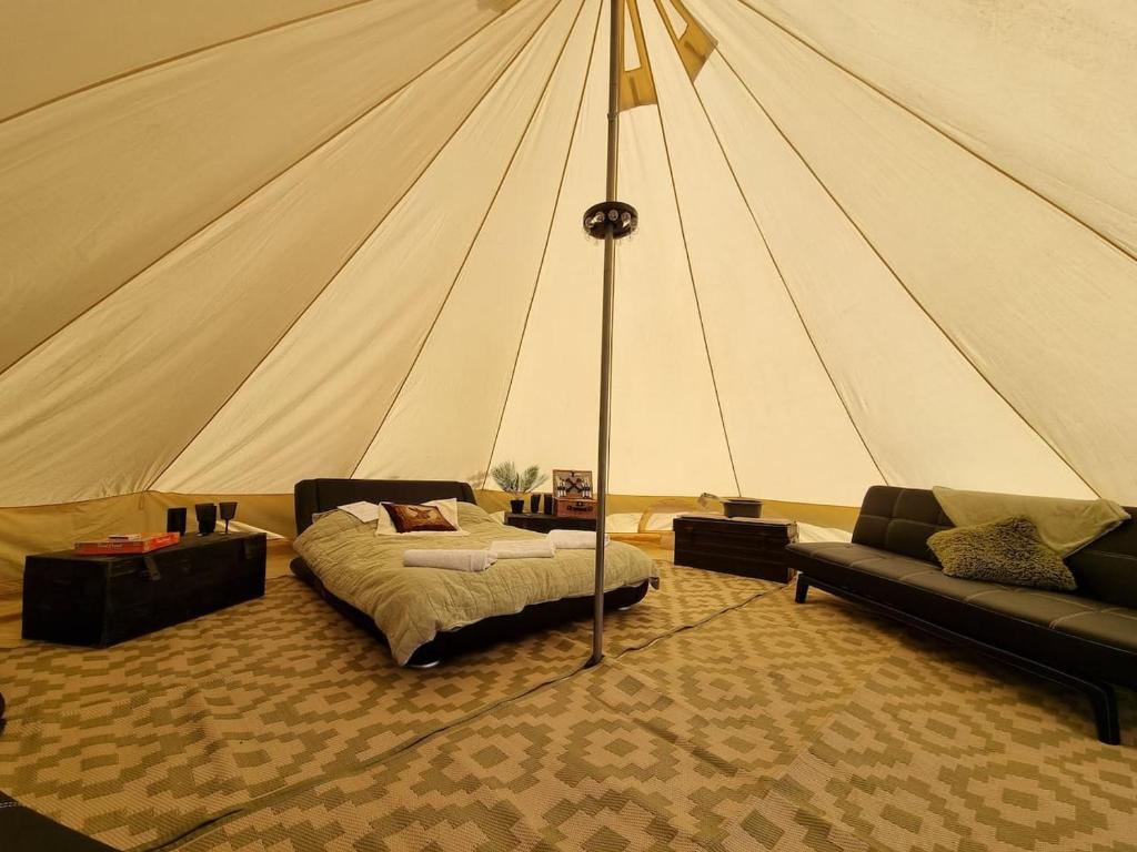 IfieldGlamping in style Bell tent的一个带一张床和一张沙发的帐篷