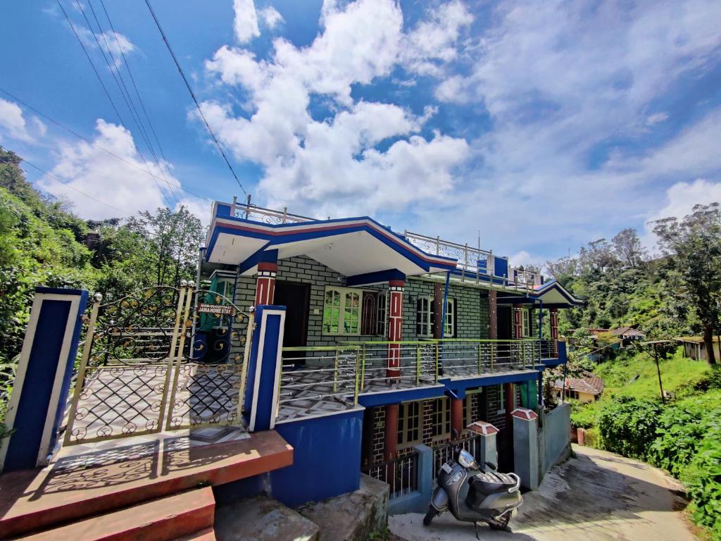 马迪凯里Jawa Homestay的一座色彩缤纷的房屋,前面设有围栏