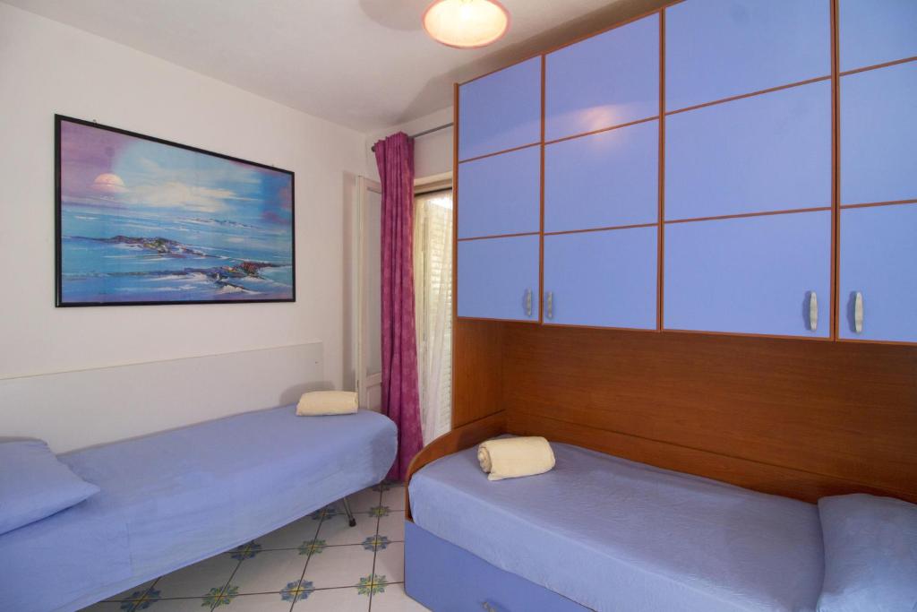 伊斯基亚La Turrita Apartments的一间设有两张床和橱柜的房间