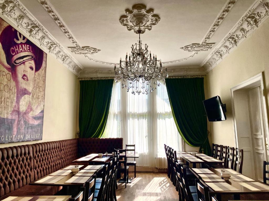 柏林选帝侯大街昂普罗姆酒店的一间带桌椅和吊灯的用餐室