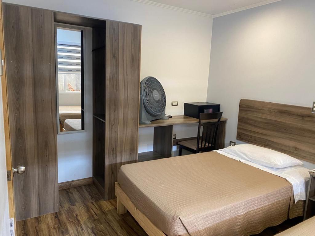 阿里卡Hotel Amaru Express的一间卧室配有一张床和一张带窗户的书桌