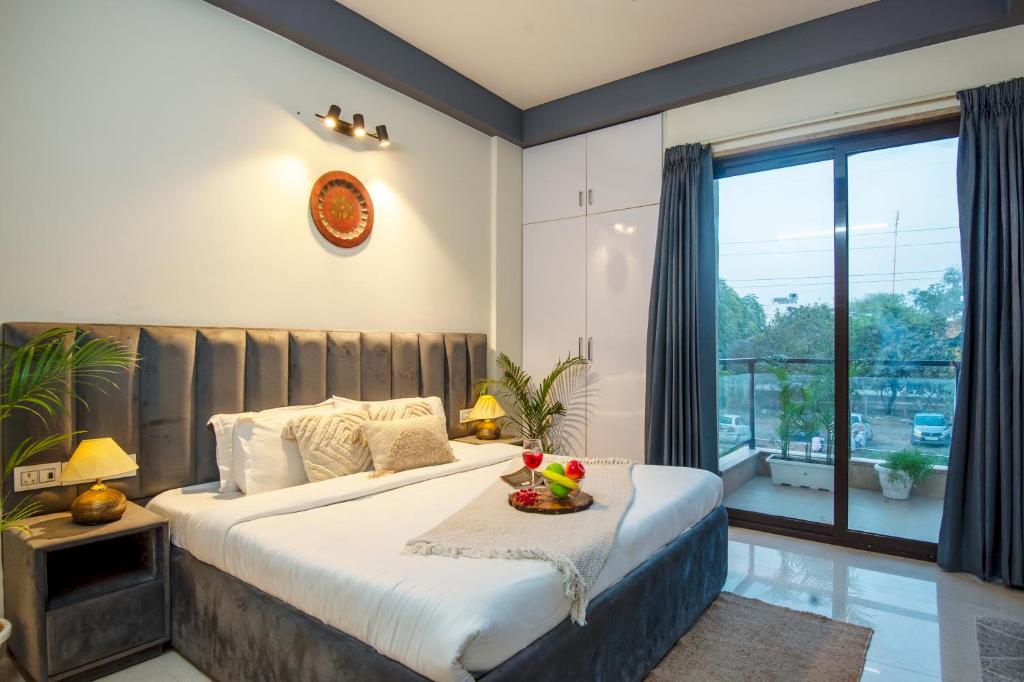 古尔冈Serviced Apartment near Medanta by BedChambers的一间卧室设有一张大床和一个大窗户