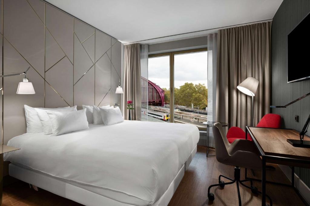 安特卫普NH Collection Antwerp Centre的配有一张床、一张书桌和一扇窗户的酒店客房