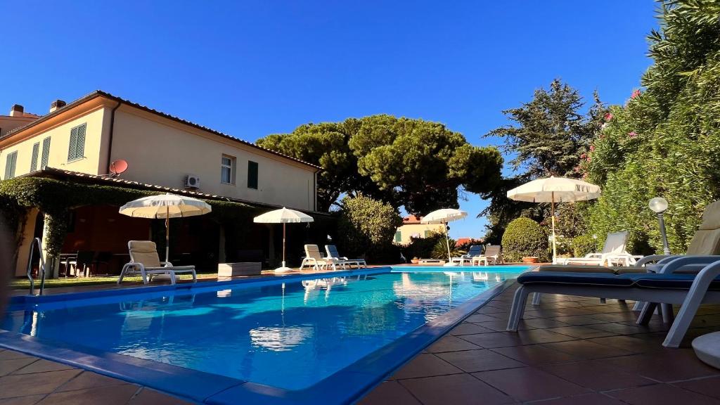 马西亚娜马里纳Residence Il Gabbiano Azzurro的庭院内带椅子和遮阳伞的游泳池