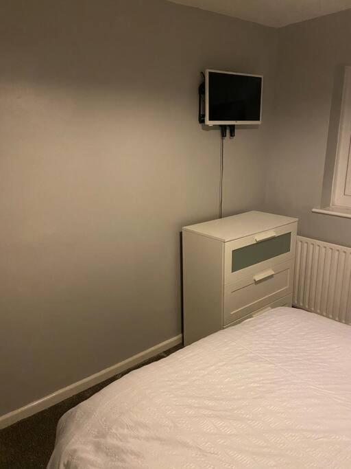 ShephallCosy 1 Bed Home @Stevenage的卧室配有一张床,墙上配有电视。