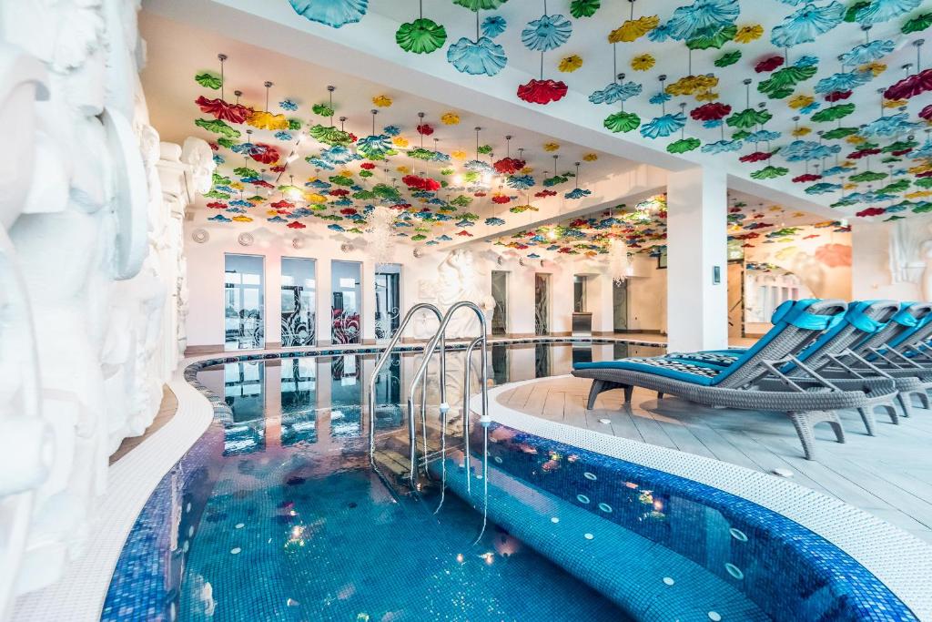 科利比塔Villa Galleria的一座酒店游泳池,天花板上布满了鲜花