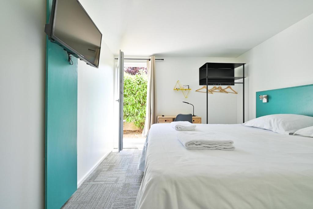 Saint-Aubin平衡骑士酒店的卧室配有白色的床和平面电视。