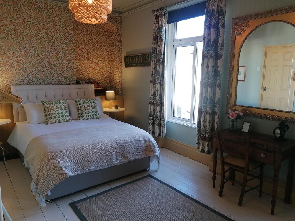 阿伯代尔No. 30的一间卧室设有一张床、一个窗口和一面镜子